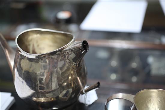 A stylish 1970s silver four piece tea set with tea strainer by Graham Watling of Lacock, gross 51 oz.